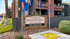 Las Vegas apartment for rent - A sign for Pleasant Hill Village Apartments in front of a building.