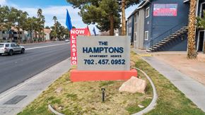 Las Vegas apartment for rent - A sign for The Hamptons Apartment Homes is displayed in front of a building.
