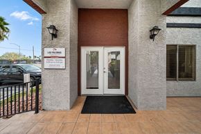 Las Vegas apartment for rent - The entrance to a building with a sign that reads "Las Palomas" and a black doormat in front.