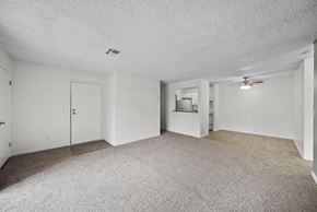 Las Vegas apartment for rent - A spacious room with a carpeted floor and a ceiling fan.