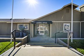 Banning apartment for rent - A leasing office building entrance with a bench and a sunny day.