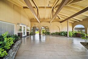 Fullerton apartment for rent - A long hallway with a stone floor and arched doorways.
