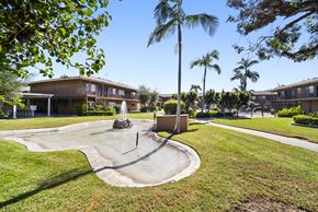 Fullerton apartment for rent - A playground with a slide in the middle of a grassy area.
