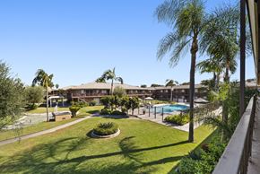 Fullerton apartment for rent - A view of a pool and a building from a balcony.