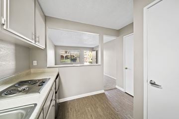 Fullerton apartment for rent - A kitchen with white cabinets and a stove top oven.