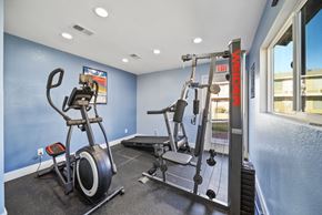 Hesperia apartment for rent - A gym room with a weight machine and a stationary bike.