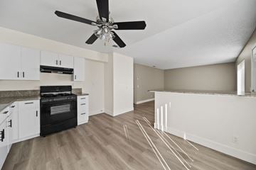 Hesperia apartment for rent - A kitchen with a black stove top oven and white cabinets.
