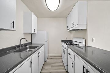 Phoenix apartment for rent - A kitchen with white cabinets and a stove top oven.