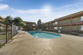 Phoenix apartment for rent - A pool in a courtyard surrounded by a fence.