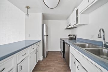 Phoenix apartment for rent - A kitchen with white cabinets and a wooden floor.