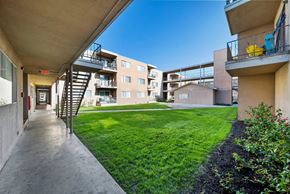 Hawthorne apartment for rent - A view of a balcony with a yellow chair and a building in the background.
