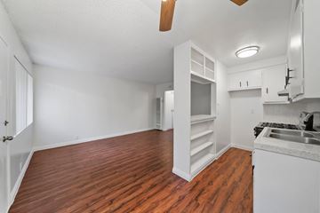 Hawthorne apartment for rent - A kitchen with white cabinets and a wooden floor.