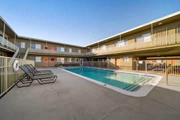 Hawthorne apartment for rent - A pool area with sun loungers and a fence.
