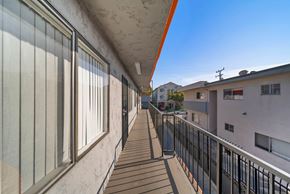 Hawthorne apartment for rent - A long balcony with a black railing and a white wall.