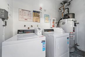 Hawthorne apartment for rent - A white industrial machine sits in a room with a white wall and a sign that says "OPERATION INSTRUCTIONS" on the wall.