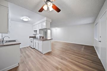 Hawthorne apartment for rent - A kitchen with white cabinets and a wooden floor.