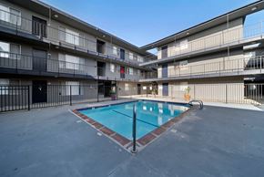 Hawthorne apartment for rent - A swimming pool in the middle of a courtyard surrounded by apartment buildings.
