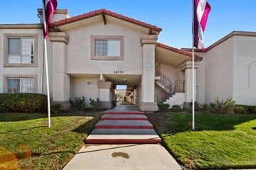 Palmdale apartment for rent - A building with a red roof and a flag on top of it.
