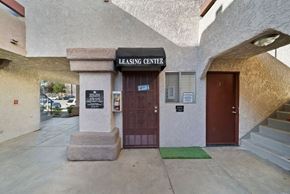 Palmdale apartment for rent - The leasing center has a brown door and a green mat on the steps.