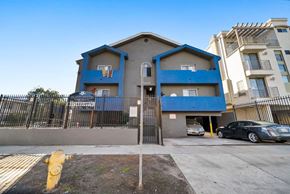 North Hollywood apartment for rent - A blue and beige two-story apartment building with a basketball hoop on the first floor.