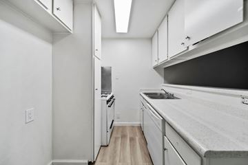 North Hollywood apartment for rent - A kitchen with white cabinets and a black counter top.