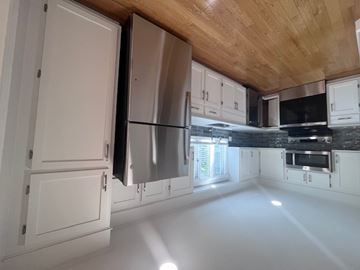 Wellesley apartment for rent - A kitchen with white cabinets and a wooden ceiling.