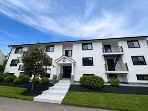 Yarmouth apartment for rent - A white two-story building with black railings and windows.