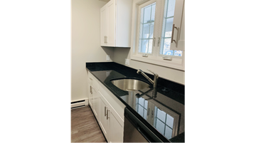 Yarmouth apartment for rent - a kitchen with black counter tops and white cabinets