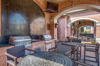 Patio with a table and chairs and a grill