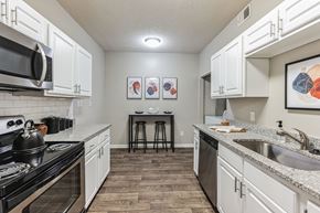 Cary apartment for rent - a spacious kitchen with white cabinets and granite counter tops  at Harrison Grande, Cary, 27513