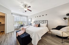 San Antonio apartment for rent - A bedroom with a white bed and a ceiling fan at The Atlantic Stone Oak Apartments, San Antonio