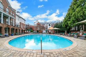 Atlanta apartment for rent - A large swimming pool surrounded by lounge chairs and buildings at The Atlantic Buckhead Apartments, Georgia 30305