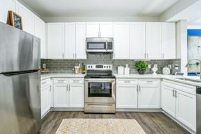 Atlanta apartment for rent - A kitchen with white cabinets and a stainless steel refrigerator at The Atlantic Buckhead Apartments, Atlanta, GA, 30305