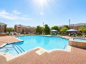 Mckinney apartment for rent - A sunny day at the pool with apartment buildings in the background.
