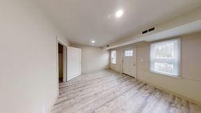 Berkeley apartment for rent - A spacious room with wooden flooring and white walls.