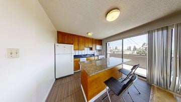 Berkeley apartment for rent - A kitchen with a white refrigerator and wooden cabinets.