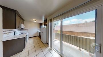 Berkeley apartment for rent - A kitchen with a white counter top and a window with a view of a building.