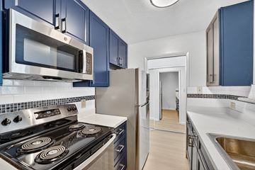 Berkeley apartment for rent - A kitchen with blue cabinets and stainless steel appliances.