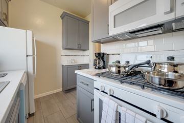 Berkeley apartment for rent - A kitchen with a white stove top oven and a white refrigerator.