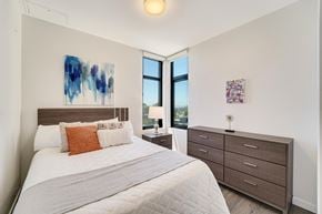 Berkeley apartment for rent - A bedroom with a large bed, a nightstand with a lamp, and two pieces of artwork on the wall.