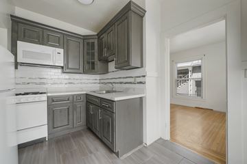 Berkeley apartment for rent - A kitchen with white appliances and dark wood cabinets.