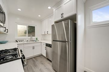 Oakland apartment for rent - A modern kitchen with a stainless steel refrigerator and a black gas stove.