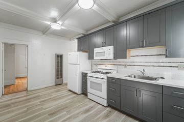 Berkeley apartment for rent - A kitchen with white appliances and grey cabinets.