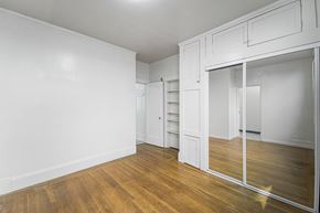 Berkeley apartment for rent - A room with white walls and wooden floors with a large mirror on the wall.