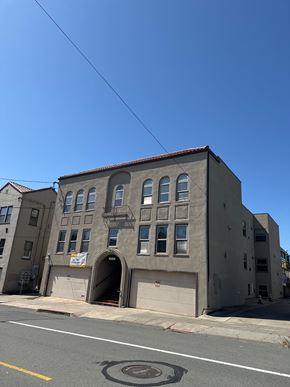 Berkeley apartment for rent - A grey building with a red tile roof and a garage door.