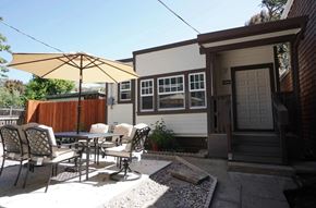 Berkeley apartment for rent - A patio with a table and chairs is set up outside a house.