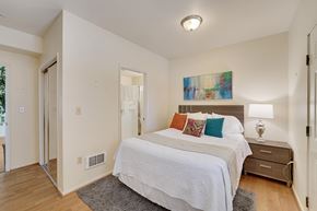Berkeley apartment for rent - A bedroom with a white bed and a painting on the wall.