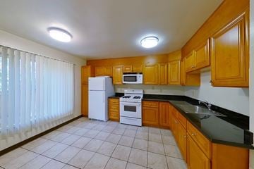 Berkeley apartment for rent - A kitchen with wooden cabinets and black countertops.