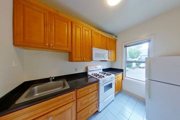 Berkeley apartment for rent - A kitchen with wooden cabinets and a white refrigerator.