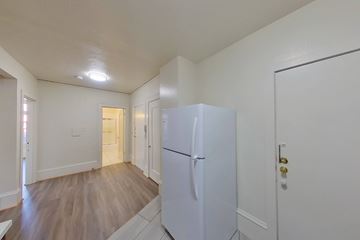 Berkeley apartment for rent - A white refrigerator in a kitchen with wood flooring.